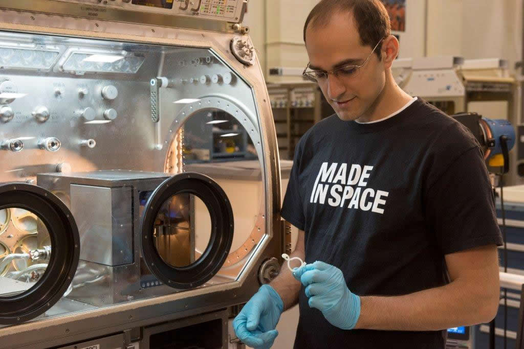 Deputy Program Manager Matthew Napoli examines a 3D printed piece at Marshall Space Flight Center. (Image Courtesy of NASA/MSFC/Deaton)