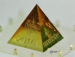 The sides of this 3D-printed miniature replication of the Karlsruhe pyramid features the logos of HeKKSaGOn, KIT, and Nanoscribe. It has a total height of only 2 mm. (Photo courtesy of Nanoscribe GmbH)