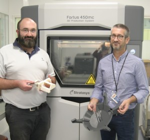 Frédéric Tremoulet, 3D Printer Manager and Mathieu Dumora, UPSA Project Manager, holding 3D printed production tools for the camera mounts (Photo: Business Wire)